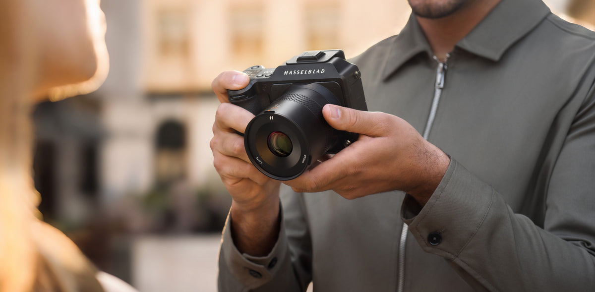 Fotograf mit Hasselblad-Mittelformatkamera fotografiert eine Person in der Stadt